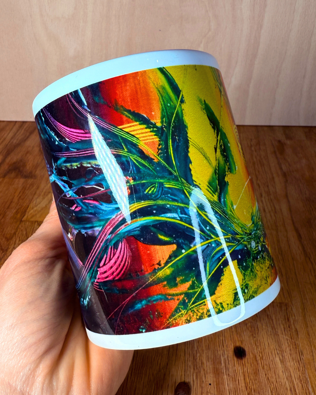 Dopamine Deco Tasse in der Hand gehalten – Detail des farbenfrohen Designs in Gelb, Orange und Grün