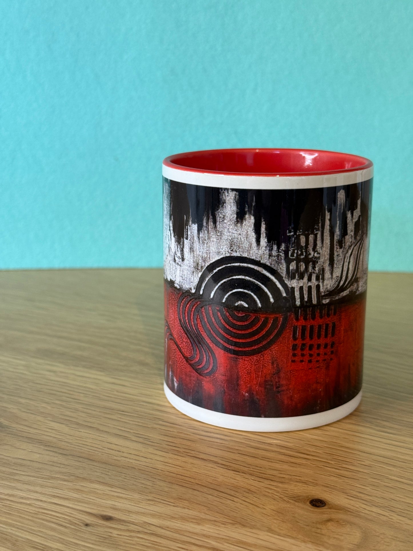 Herz Design Tasse schwarz-rot Frontalansicht – abstraktes Panorama-Kunstmotiv mit Skyline, Spiralen und grafischen Elementen auf türkisem Hintergrund