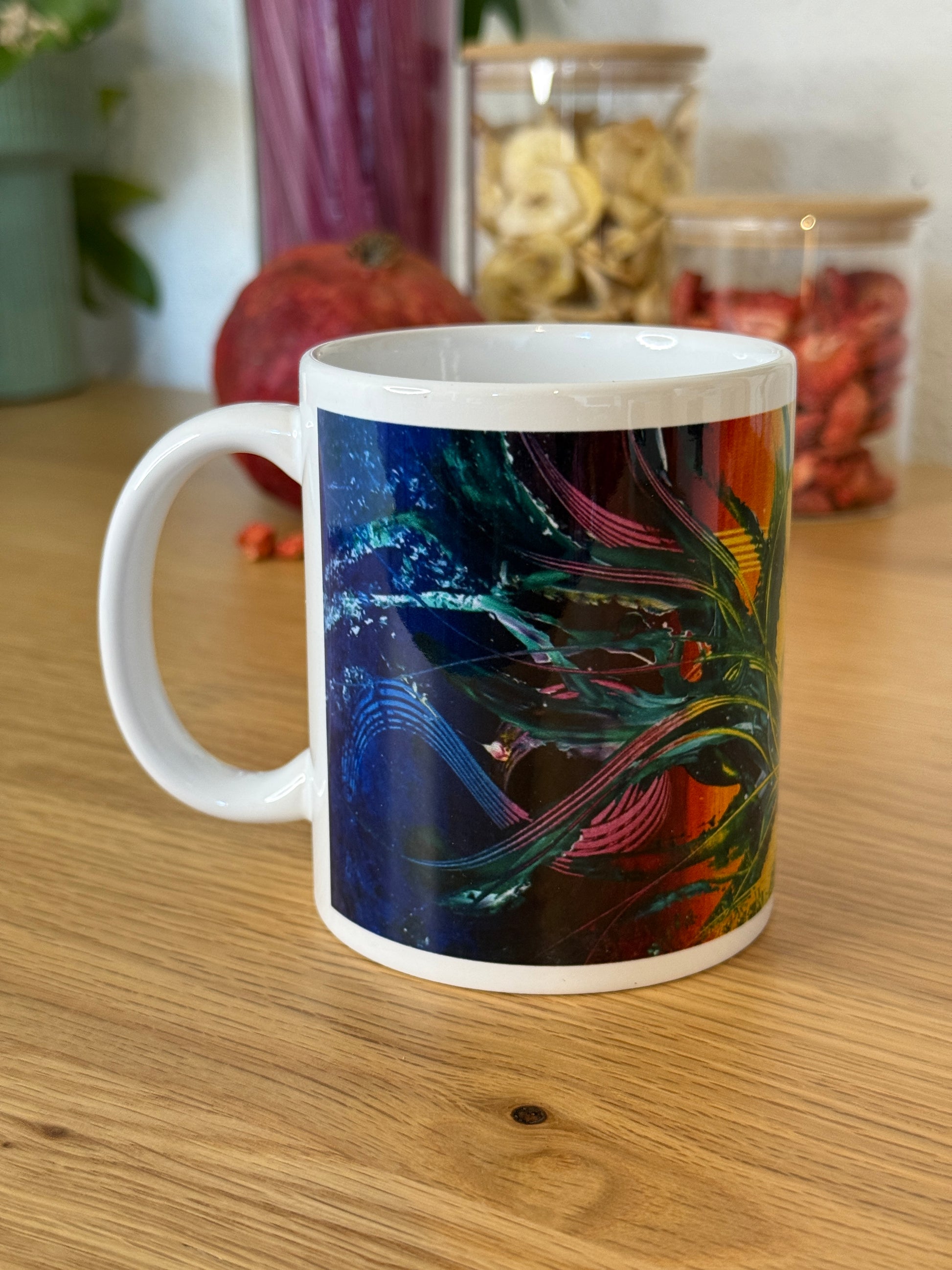 Abstrakte Kunst Tasse mit tropischem Pflanzen-Motiv in Grün, Blau und Pink – Seitenansicht mit Henkel auf Holztisch