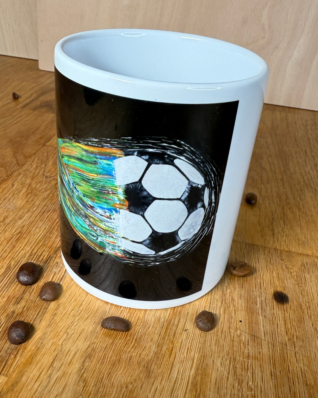 Fußballtasse in der Hand gehalten – Detailansicht des Fußball-Kunstmotivs