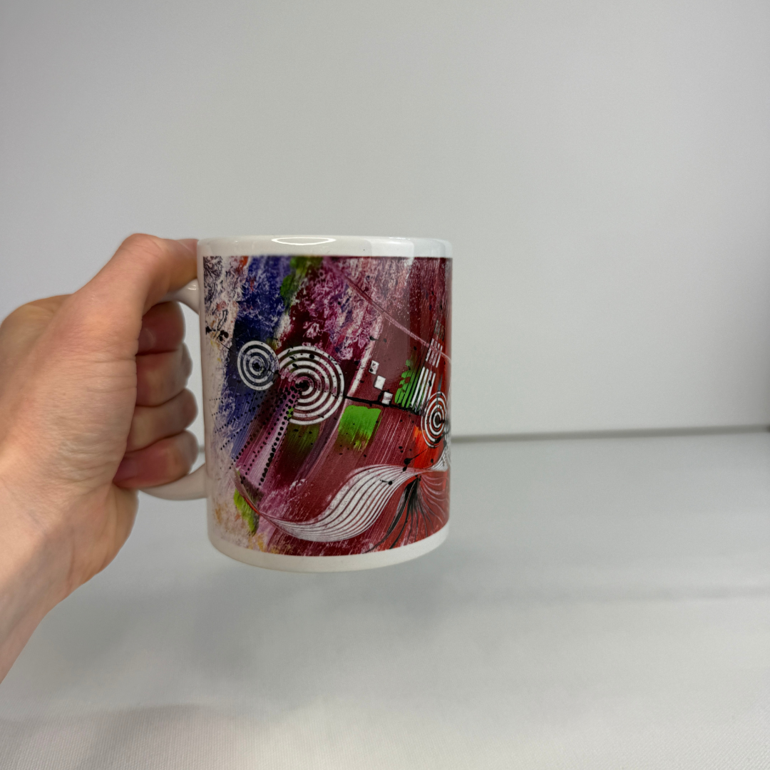 Hand hält Bunten Keramik-Becher mit abstraktem, mehrfarbigem Design in modernen Regenbogenfarben.