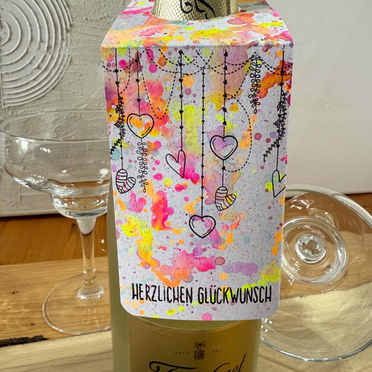 Handgemachter Flaschenanhänger Geburtstag. Neonfarbenes Design mit bunten Spritzern und Spruch Herzlichen Glückwunsch. Geschenk.