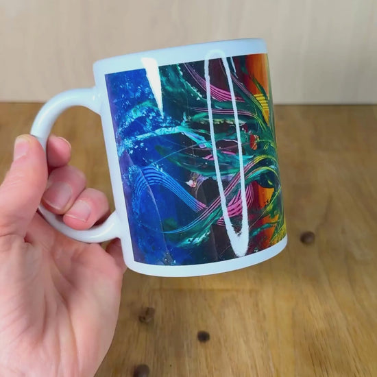 Bunte Kaffeetasse wird von Hand gehalten für Rundumsicht.