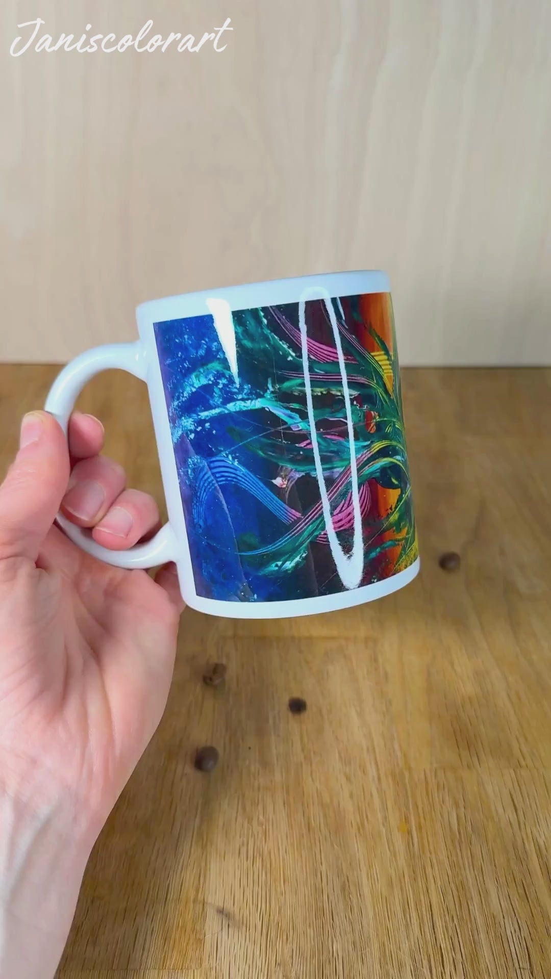 Bunte Kaffeetasse wird von Hand gehalten für Rundumsicht.